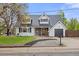Charming two-story home featuring dormer windows, a manicured lawn, and a cozy covered front porch at 12212 W 60Th Pl, Arvada, CO 80004