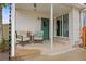 Inviting covered front porch with neutral furniture, a green front door and sliding glass doors at 12212 W 60Th Pl, Arvada, CO 80004