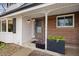 Inviting front porch with a covered entrance, wood accents, decorative plants, and a bay window to the left at 12212 W 60Th Pl, Arvada, CO 80004