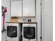 Well-organized laundry room with washer, dryer, and overhead storage cabinets at 12212 W 60Th Pl, Arvada, CO 80004