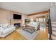 Bright living room features hardwood floors, a brick fireplace, and an open connection to another living area at 12212 W 60Th Pl, Arvada, CO 80004