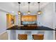 Stylish home bar with granite countertop, wood cabinets, and pendant lighting at 372 Castlemaine Ct, Castle Rock, CO 80104