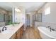 Bathroom with wood-look tile floor, standalone tub and frameless glass shower at 372 Castlemaine Ct, Castle Rock, CO 80104