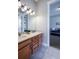 Bathroom with double sink, wood cabinets, tile floor, and view into adjacent room at 372 Castlemaine Ct, Castle Rock, CO 80104