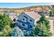 An aerial view highlights the house and its backyard featuring mature trees and a patio area at 3779 Aspen Hollow Ct, Castle Rock, CO 80104