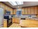 Well-lit kitchen with oak cabinets, modern appliances, and a breakfast bar at 3779 Aspen Hollow Ct, Castle Rock, CO 80104