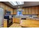 Well-lit kitchen with stainless steel refrigerator, oven, microwave, and wood cabinets at 3779 Aspen Hollow Ct, Castle Rock, CO 80104