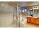 Bright bathroom with a shower, soaking tub, and a wood vanity with a sink and mirror at 3779 Aspen Hollow Ct, Castle Rock, CO 80104