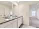 Bathroom featuring double sinks, gray countertops and a view into the bedroom at 7185 Waterleaf Trl, Littleton, CO 80125