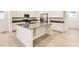Modern kitchen with white cabinets, black countertops, stainless steel appliances, and a central island at 7185 Waterleaf Trl, Littleton, CO 80125