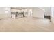 Bright, open-concept living area with light wood floors connecting to the kitchen and staircase at 7185 Waterleaf Trl, Littleton, CO 80125
