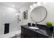Modern bathroom featuring a sleek vanity with a black countertop and a glass-enclosed shower at 1330 Quebec St, Denver, CO 80220
