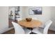 Chic dining room with round wooden table, white chairs, and a striking bull artwork at 1330 Quebec St, Denver, CO 80220