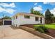 A charming house featuring an attached garage, lush front yard, and lovely landscaping at 1330 Quebec St, Denver, CO 80220