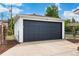Detached garage featuring a modern black door and a white brick exterior, providing secure parking at 1330 Quebec St, Denver, CO 80220
