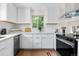 Bright white kitchen featuring stainless steel appliances, subway tile backsplash, and wooden floors at 1330 Quebec St, Denver, CO 80220