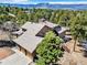 Aerial view of a home with three-car garage surrounded by lush trees and mountain views at 18940 Pebble Beach Way, Monument, CO 80132