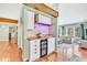 Home bar with wine refrigerator, custom cabinetry and lighting near living room at 18940 Pebble Beach Way, Monument, CO 80132