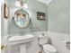 This bathroom has a pedestal sink and wainscoting at 18940 Pebble Beach Way, Monument, CO 80132