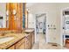 Bathroom vanity features granite countertops and wood cabinetry with an entry to the walk-in closet at 18940 Pebble Beach Way, Monument, CO 80132
