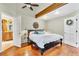 A spacious bedroom with hardwood floors, ceiling fan, and an ensuite bathroom at 18940 Pebble Beach Way, Monument, CO 80132