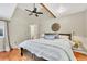 Primary bedroom with hardwood floors, a ceiling fan, and a wooden accent beam at 18940 Pebble Beach Way, Monument, CO 80132