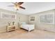 Cozy bedroom showcases a ceiling fan, two windows with decorative trim, and plush carpeting at 18940 Pebble Beach Way, Monument, CO 80132
