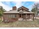 Inviting home with a red front door, dormer windows and mature trees at 18940 Pebble Beach Way, Monument, CO 80132