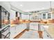 Bright kitchen features stainless steel appliances, white cabinets, tile backsplash and a farmhouse sink at 18940 Pebble Beach Way, Monument, CO 80132