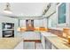 Bright kitchen with white cabinets, brick backsplash, stainless hood and stone countertops at 18940 Pebble Beach Way, Monument, CO 80132