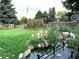Backyard featuring lush lawn, garden beds and a water feature with a bridge at 13126 W Warren Cir, Lakewood, CO 80228