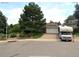 Ranch-style home with brick driveway, white garage door, landscaped yard, and an RV in front at 13126 W Warren Cir, Lakewood, CO 80228
