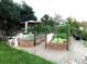 Backyard featuring raised garden beds, gravel pathways, and a relaxing seating area with an umbrella at 13126 W Warren Cir, Lakewood, CO 80228