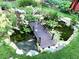 Scenic pond with a wooden bridge, lush greenery, and koi fish at 13126 W Warren Cir, Lakewood, CO 80228