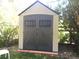Backyard storage shed with a gabled roof, double doors, and neutral-colored siding at 13126 W Warren Cir, Lakewood, CO 80228