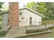 Exterior of the home featuring a brick chimney, patio area and wooden walkway at 29055 S Sunset Trl, Conifer, CO 80433