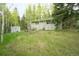 Back exterior view showing back of home and outbuilding with lots of mature trees at 29055 S Sunset Trl, Conifer, CO 80433