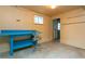 Unfinished basement area with a blue workbench, window, and concrete floor at 29055 S Sunset Trl, Conifer, CO 80433