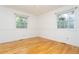 Bright bedroom with hardwood floors, white walls, two windows, and floral wallpaper trim at 29055 S Sunset Trl, Conifer, CO 80433