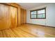 Bedroom with hardwood floors, wooden paneling, and natural light from window at 29055 S Sunset Trl, Conifer, CO 80433