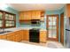 Cozy kitchen with stainless steel appliances, wood cabinets, and a tile backsplash at 29055 S Sunset Trl, Conifer, CO 80433