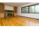 Spacious living room features a fireplace, built-in shelves, and big window at 29055 S Sunset Trl, Conifer, CO 80433