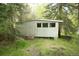 Exterior view of the outbuilding surrounded by lush greenery at 29055 S Sunset Trl, Conifer, CO 80433