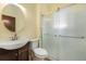 Cozy bathroom featuring a glass-enclosed shower, a modern sink, and a round mirror at 3159 36Th Ave, Denver, CO 80211