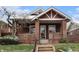 Charming brick home with a covered front porch and landscaped front yard with a dusting of snow at 3159 36Th Ave, Denver, CO 80211