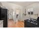Compact kitchen featuring white cabinetry, hardwood floors, arched doorway, and black appliances at 3159 36Th Ave, Denver, CO 80211