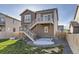 Exterior view of the home with stairs to deck and a lush lawn at 926 W Beverly St, Elizabeth, CO 80107