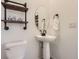 Stylish powder room with pedestal sink, decorative mirror, and modern fixtures at 926 W Beverly St, Elizabeth, CO 80107