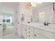 Bright bathroom with a dual sink vanity, tiled flooring, and a view from a window at 17452 W 83Rd Pl, Arvada, CO 80007