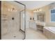 Bright bathroom with a soaking tub, dual vanity, and a walk-in shower at 17452 W 83Rd Pl, Arvada, CO 80007